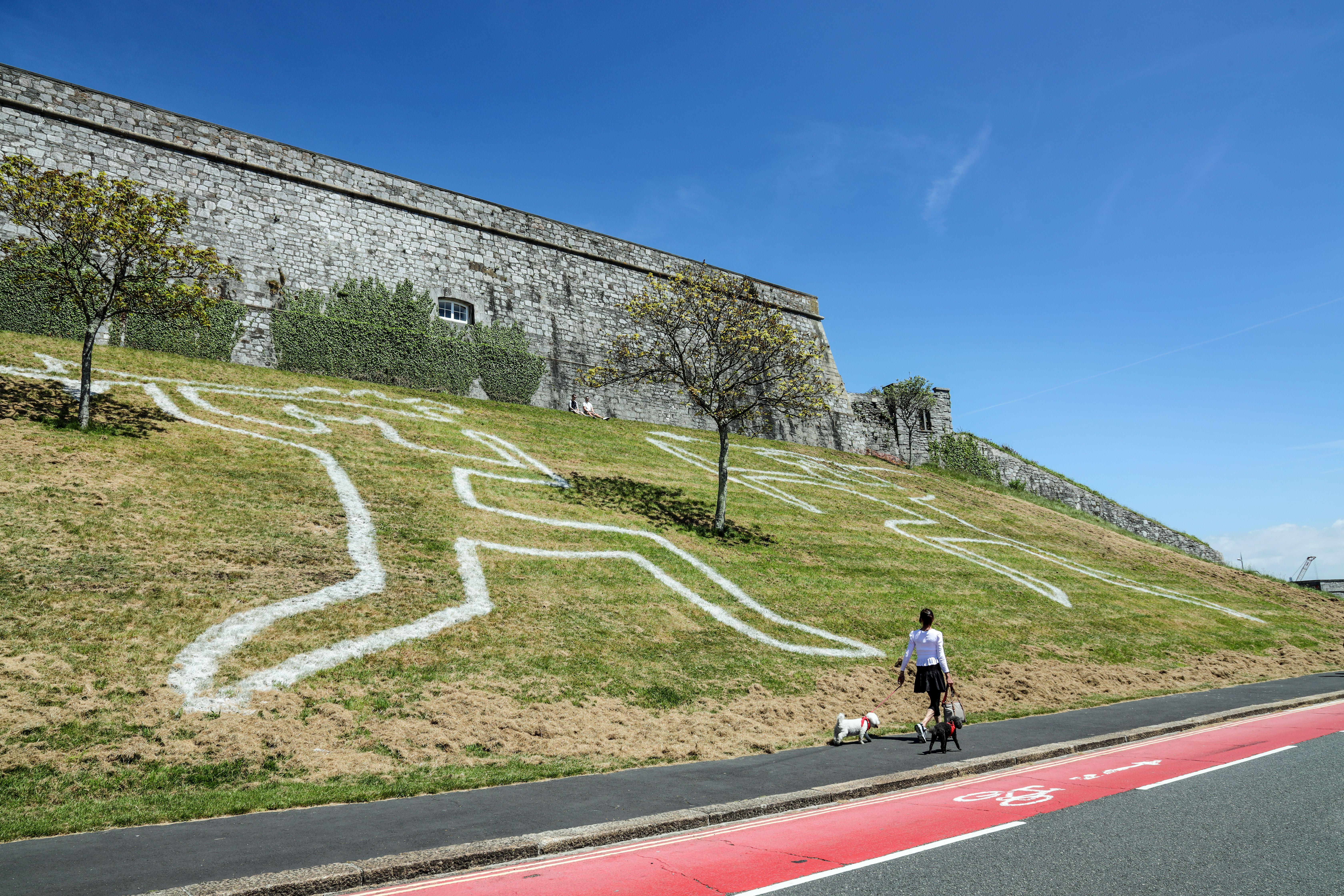 A painting of the legendary figures of Gogmagog and Corineus on the banks of a walking path.