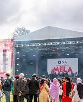 Crowd of people in front of a stage at the Mela Festival watching a performance