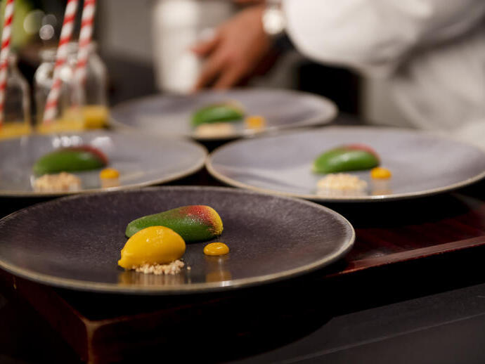 Four dishes of food on a table being prepared in a restaurant
