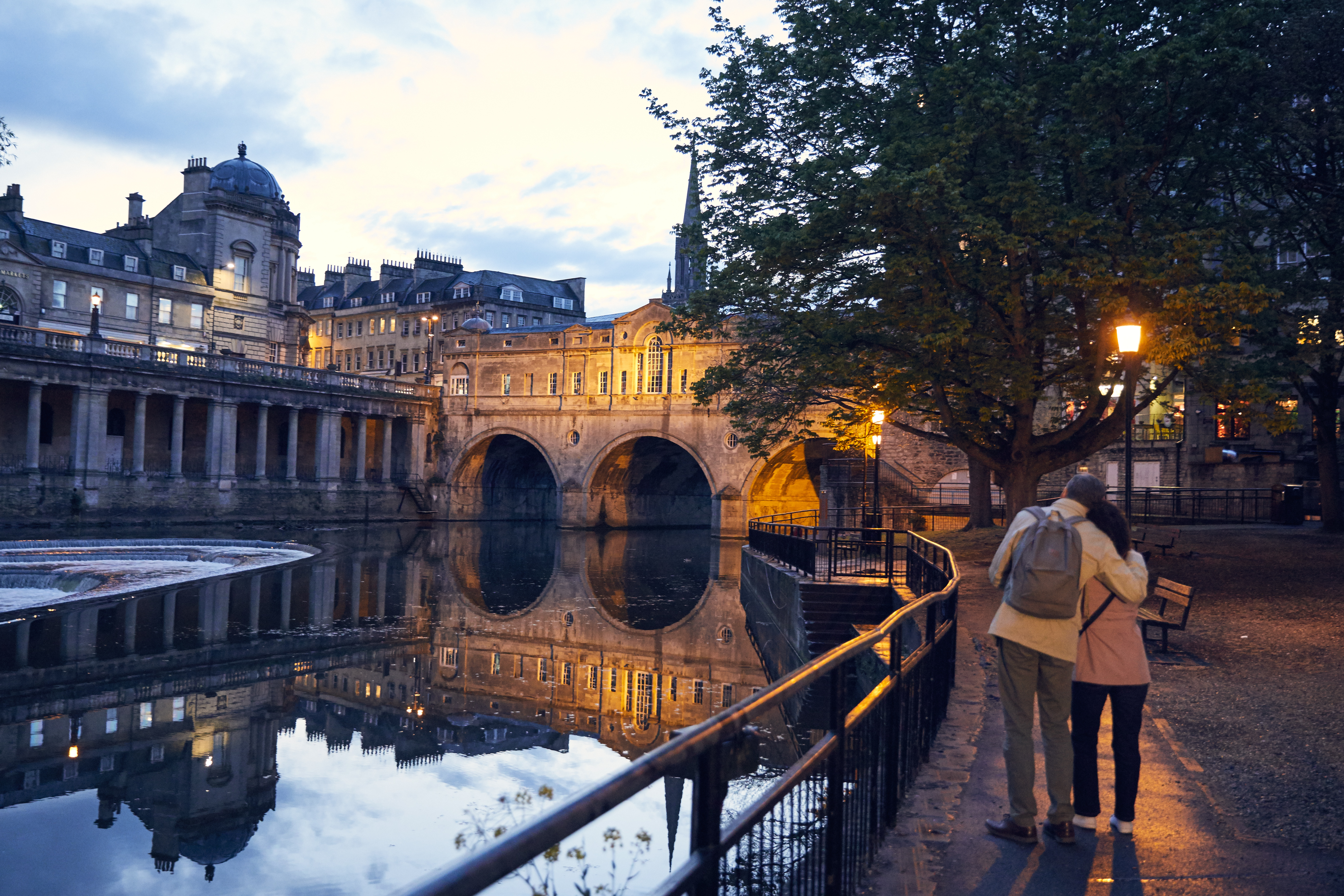 Couple strolling beside a canal in the evening