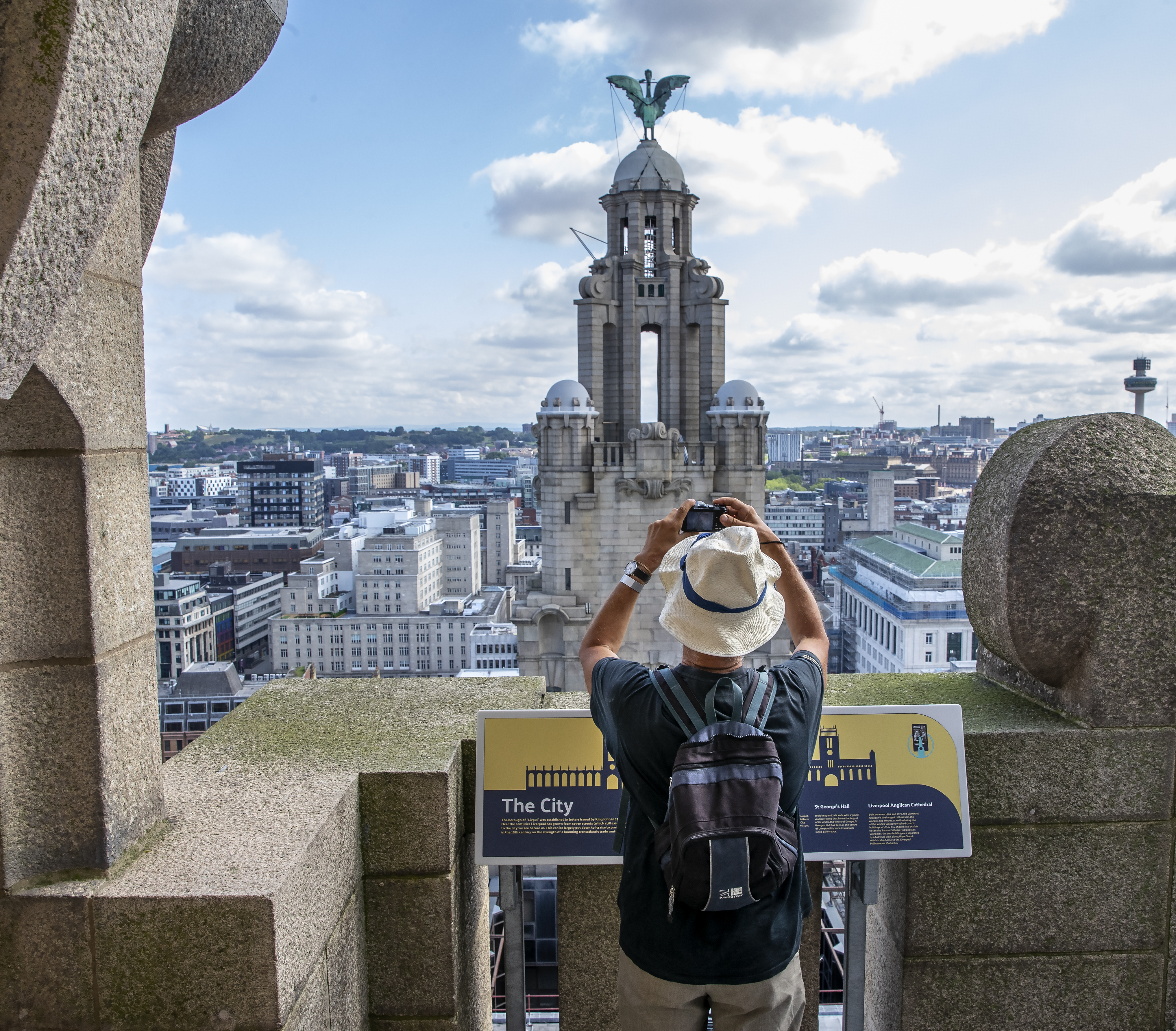 Gentleman photographing the tower in the skyline from the roof of the Royal Liver Building 360, Merseyside. 
