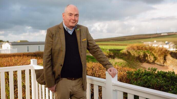 Man standing outdoor, an open field in the background