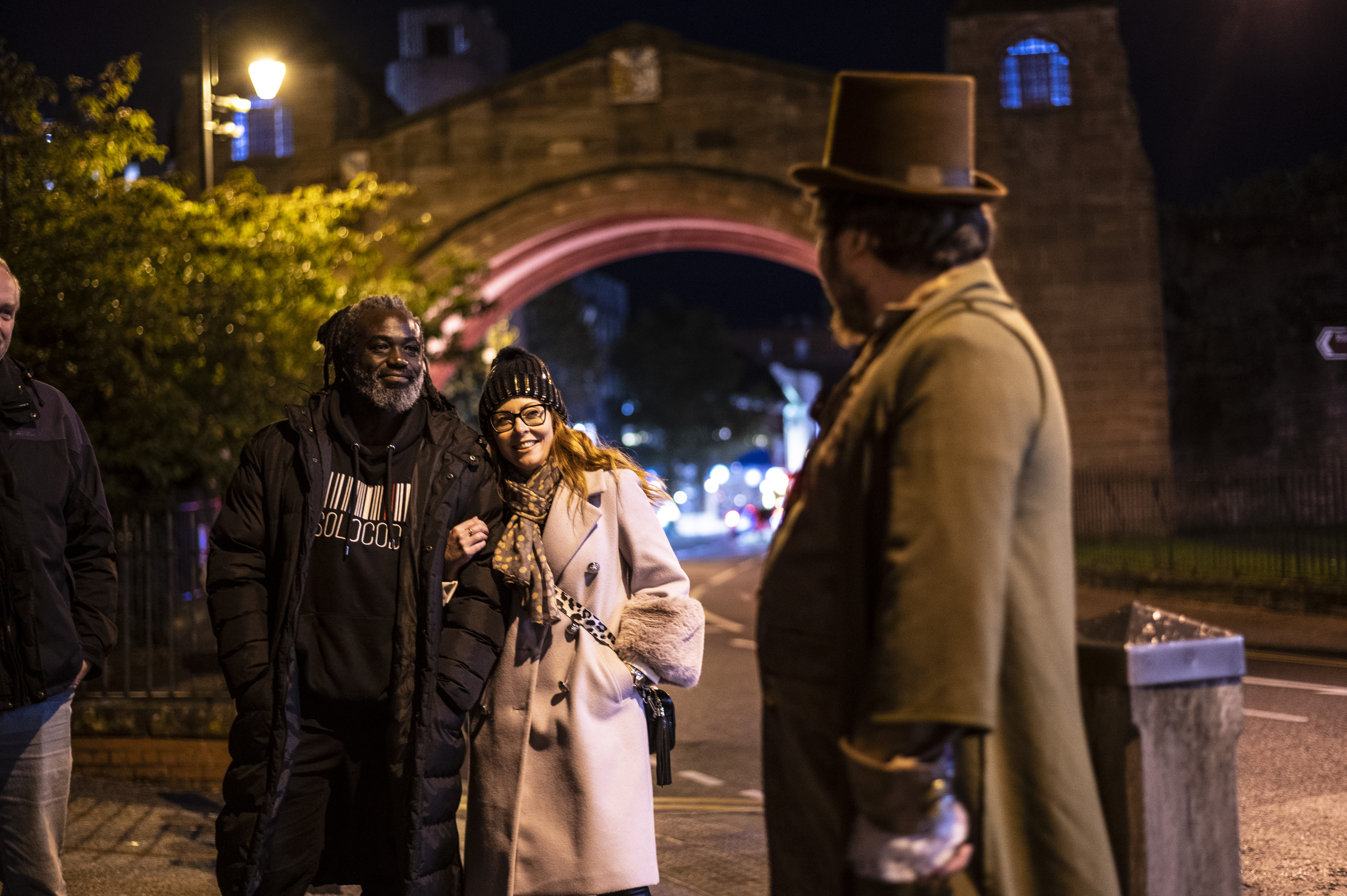 People listening to a tour guide at night as part of a ghost walk in Chester