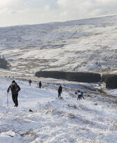 Un grupo de excursionistas, con bastones de trekking, en la nieve profunda