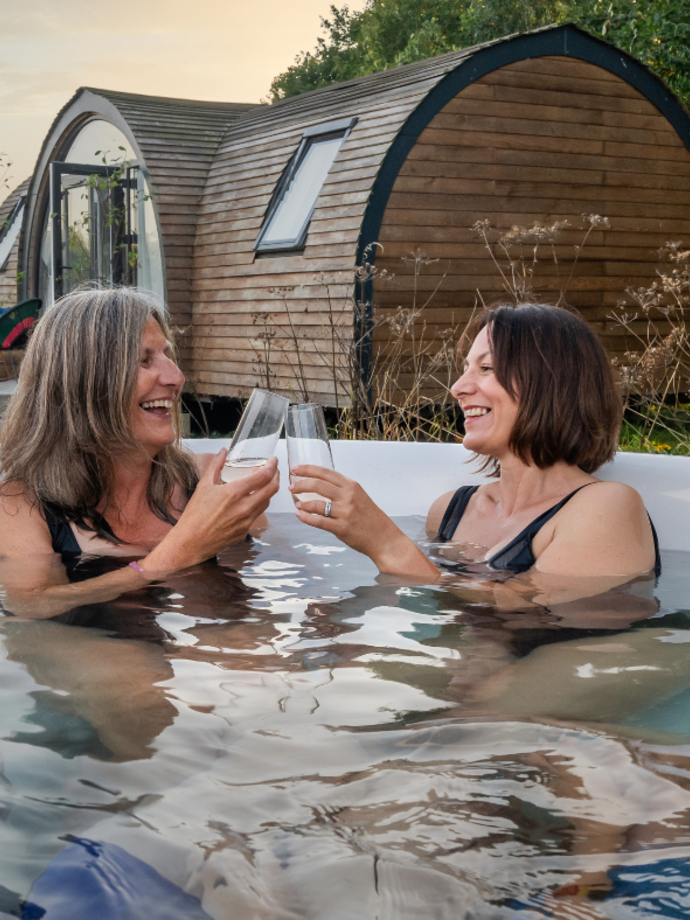 Mothers and sons in a hot tub with drinks glasses.