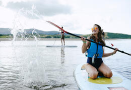 People paddle boarding in an estuary by the sea.