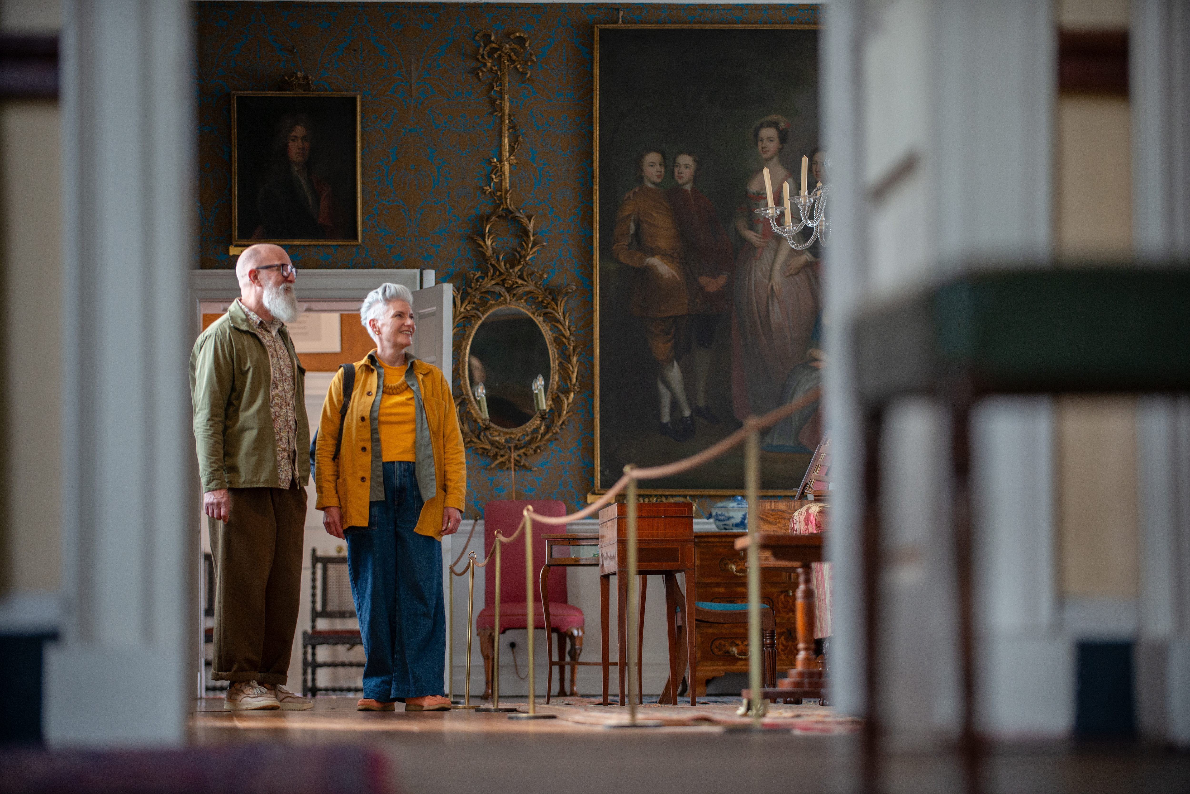 A man and a woman look toward an exhibit in a heritage property