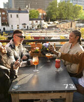 Friends enjoying outdoor drinks by a canal side beer garden