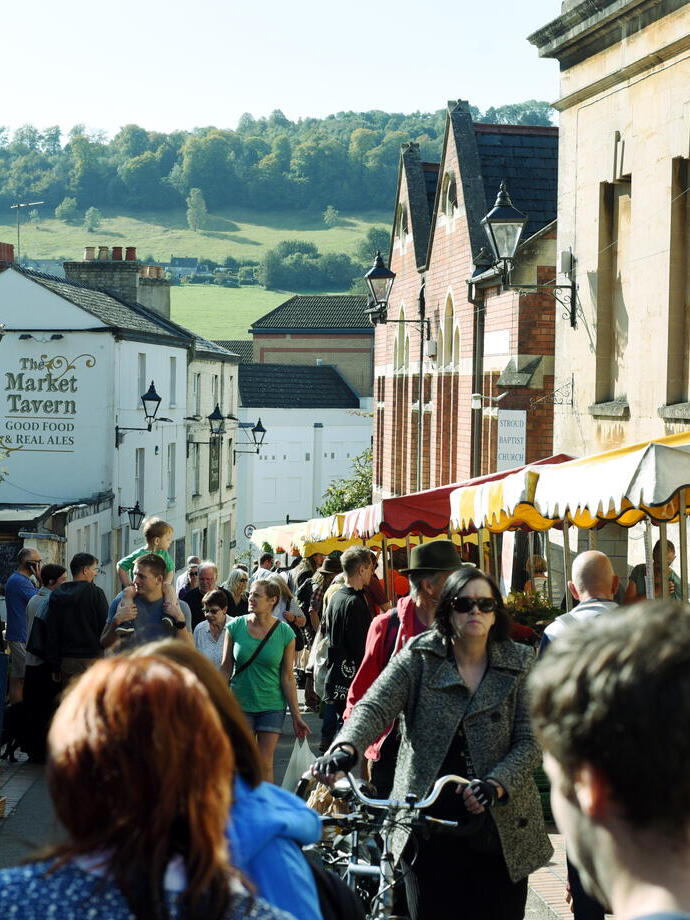 Crowds of people shopping at stalls in Stroud Farmers Market
