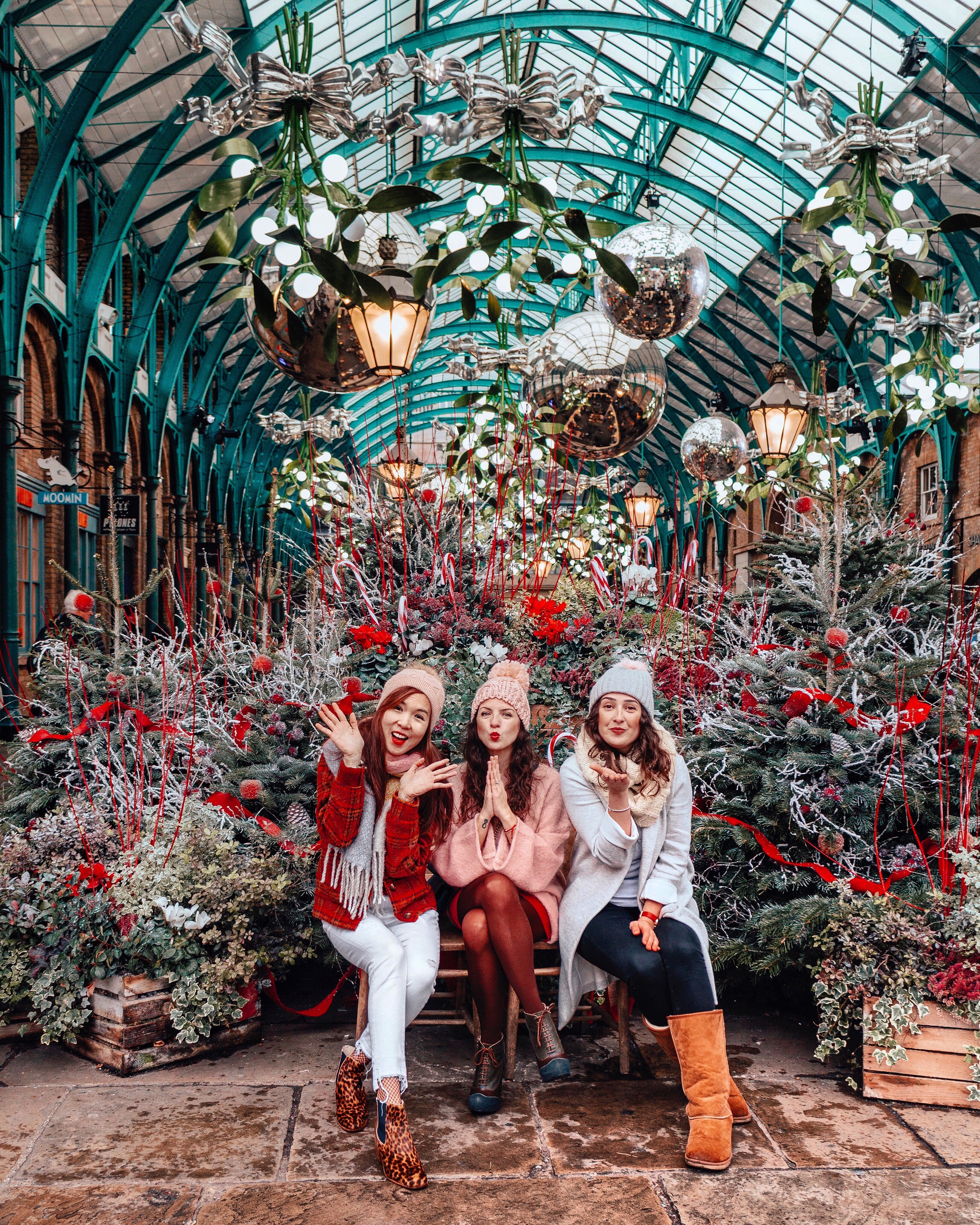 Girls sitting by Christmas trees in Covent Garden