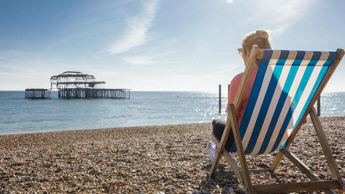 Woman sitting in a striped deckchair on a beach
