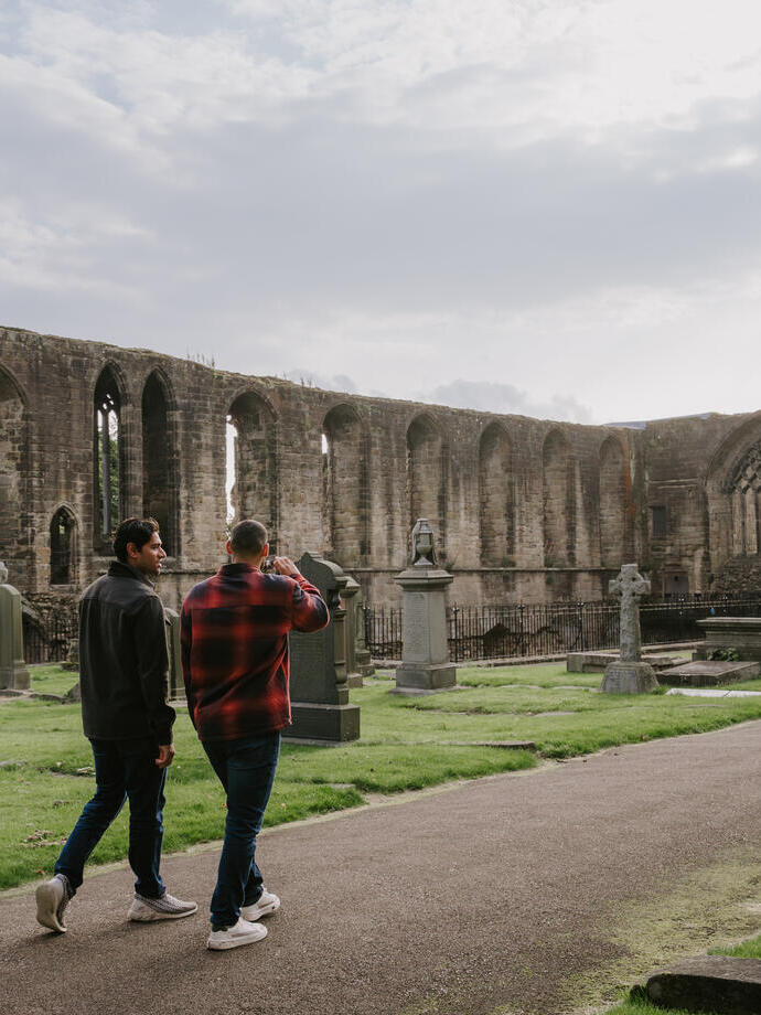 Two men walking by an Abbey Nave.