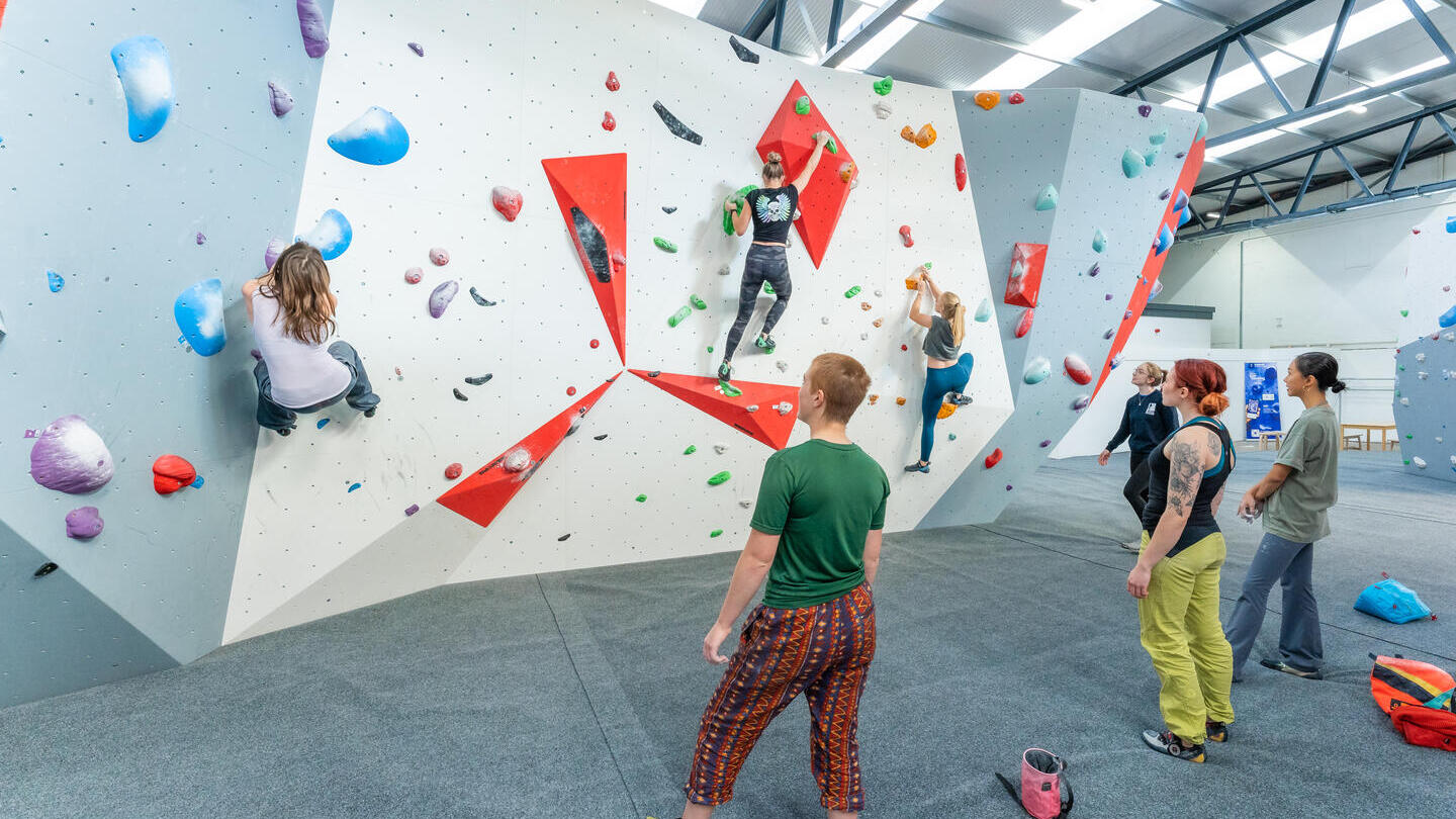 Menschen, die eine Indoor-Kletterwand in Lancashire erklimmen