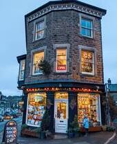 Child looking in the window of a bookshop lit up in the evening light