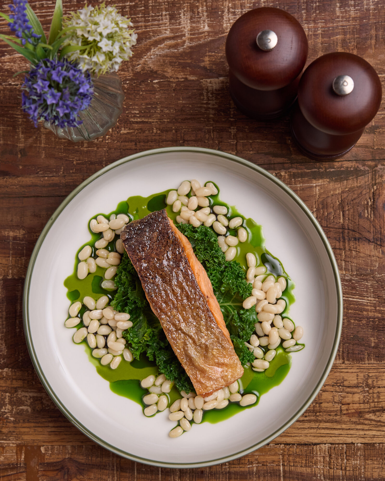 Un plat de poisson sur une feuille de chou frisé et des haricots