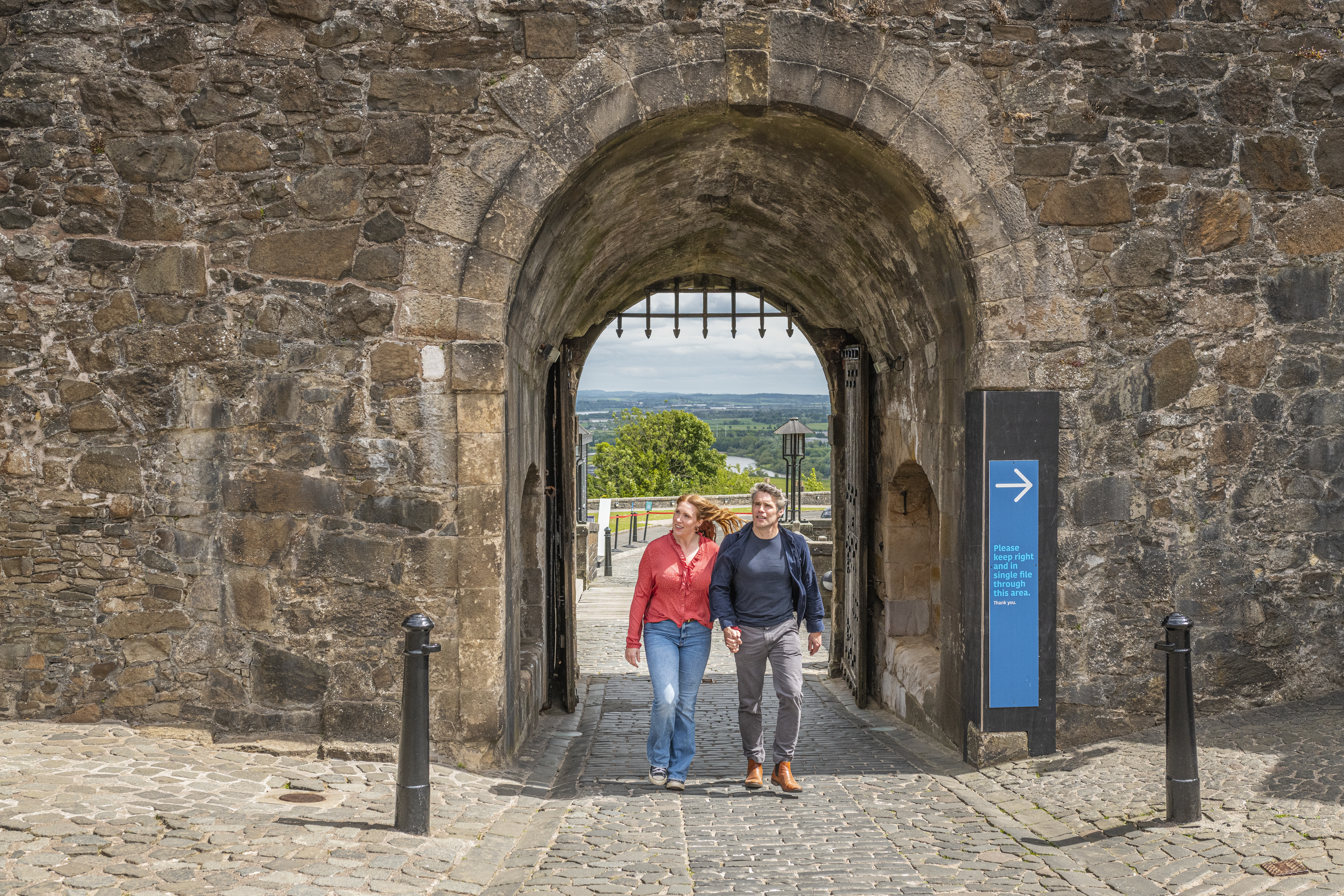 A couple exploring the grounds of a medieval castle.