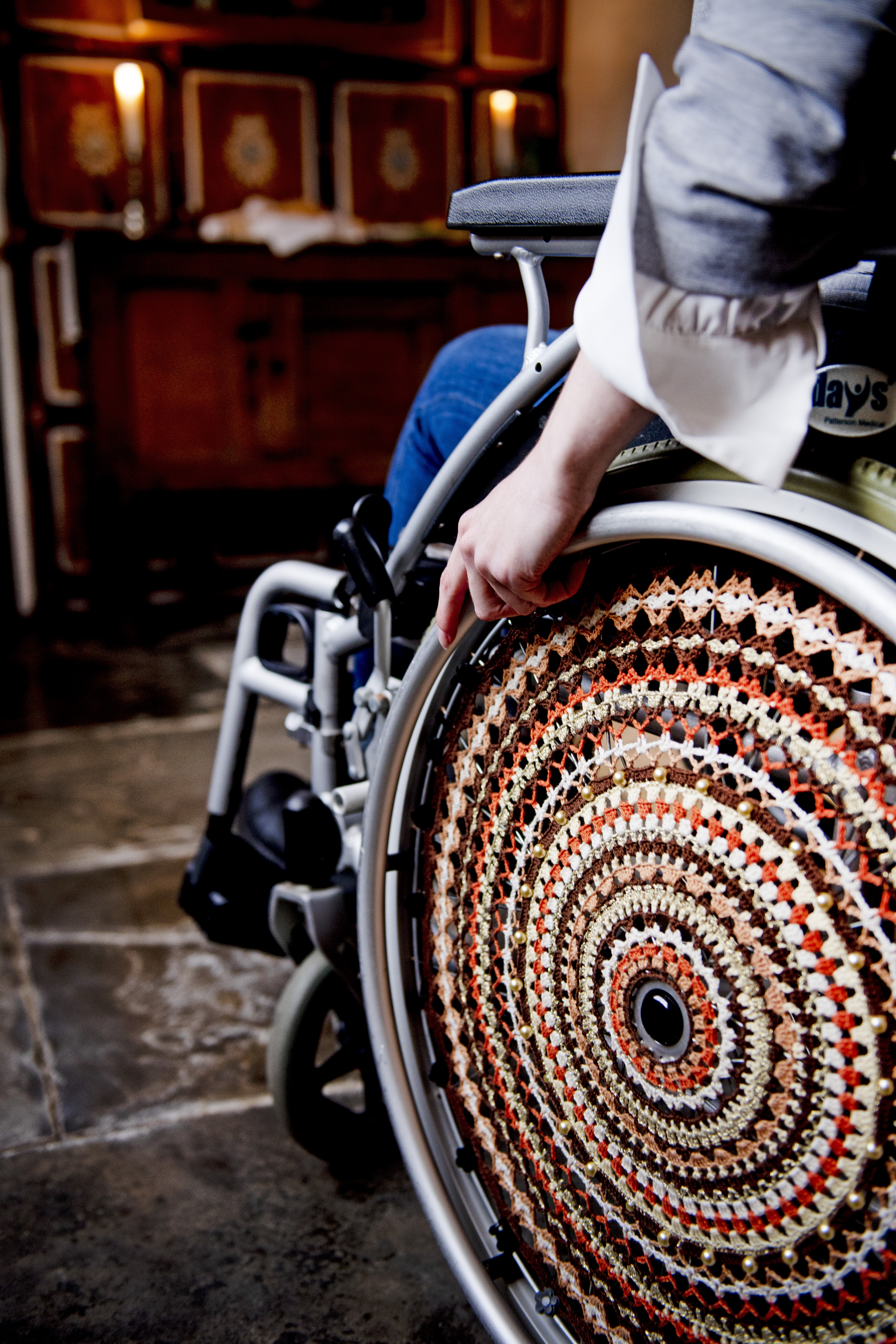 Woman in a wheelchair next to Tudor wall hangings in a historical house
