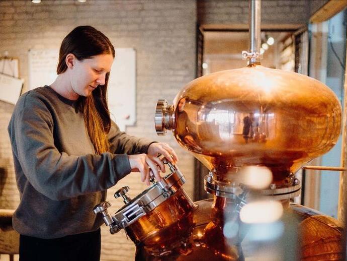 Woman looking at equipment at The Welsh Wind Distillery