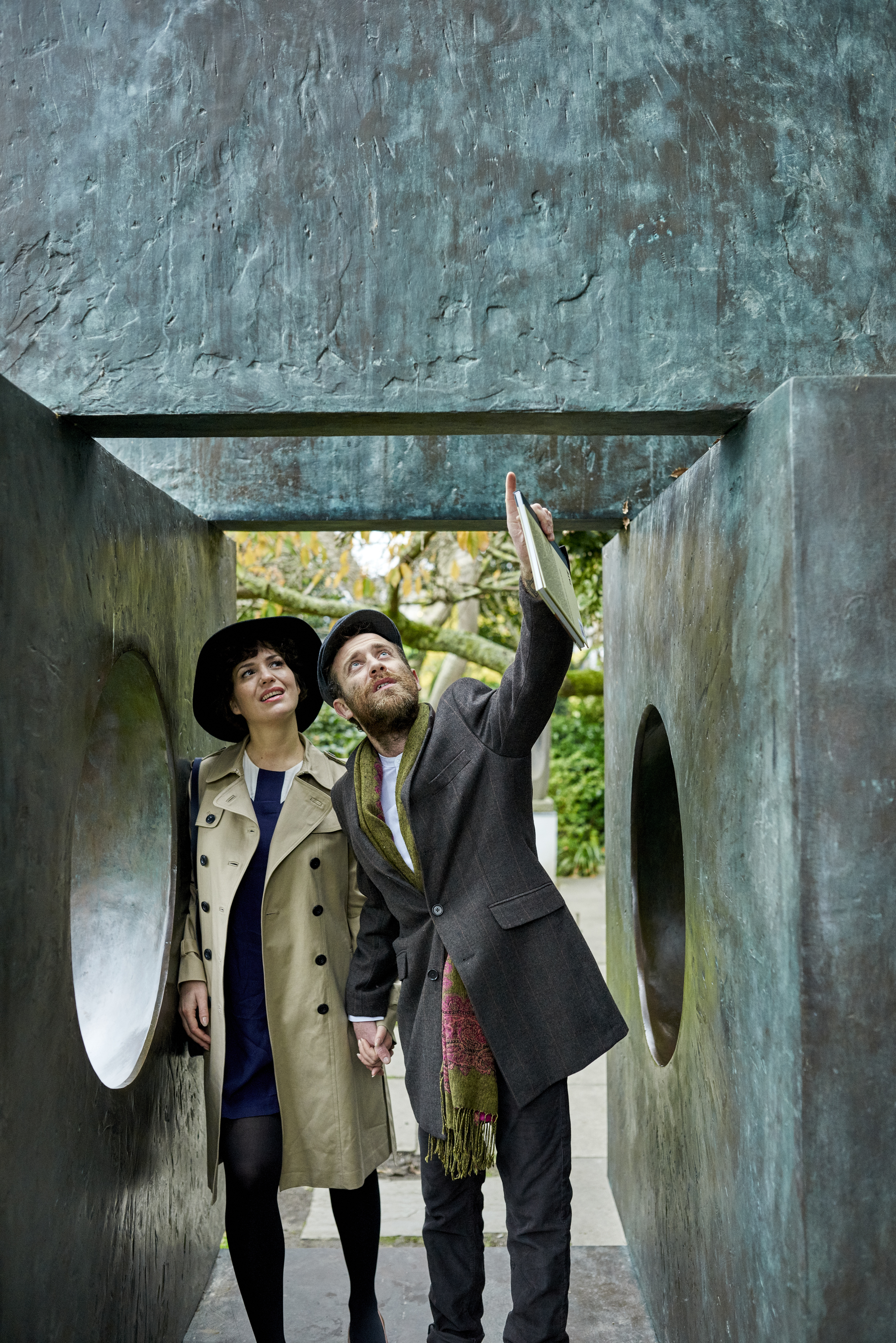 Couple standing next to bronze sculptures and installations in a garden
