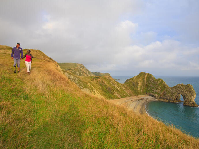 A couple walking on the clifftop in Dorset