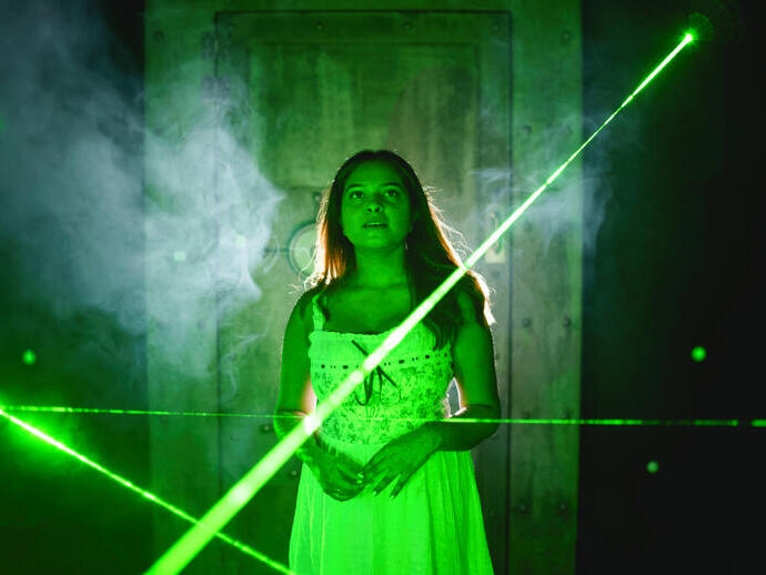 A woman enjoying the interactive escape room laser experience.