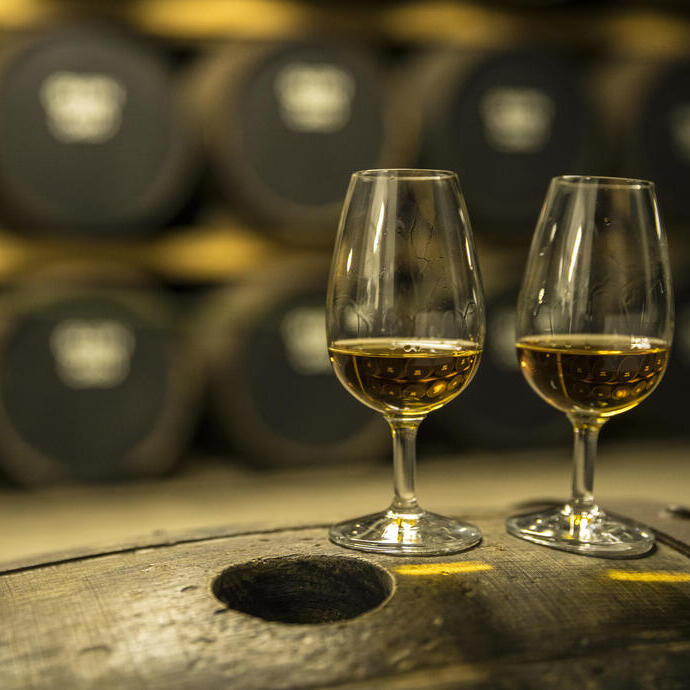 Due bicchieri di whisky su una botte di rovere