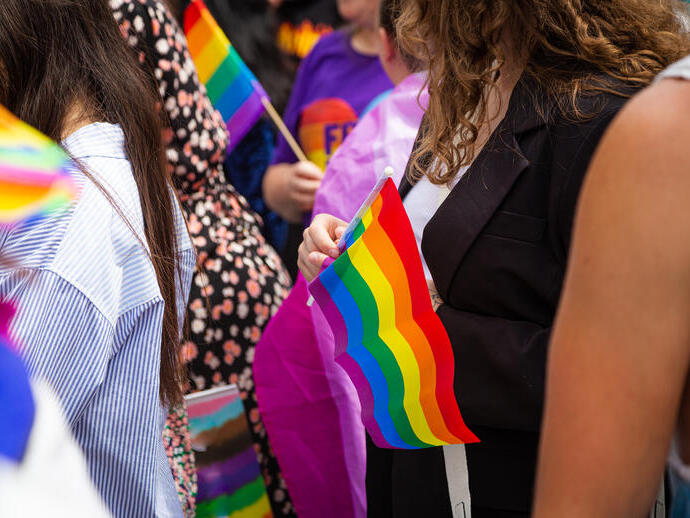 Foule brandissant des drapeaux arc-en-ciel lors d'une parade de la Pride à Londres.