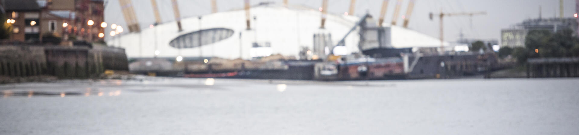 Two girls kayaking on the river in front of the O2 arena