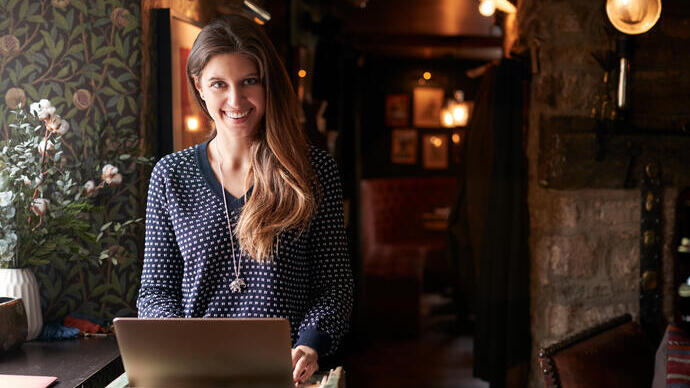Woman working on laptop at a hotel check-in desk
