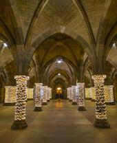 Fairy lights wrapped around pillars in a cloister