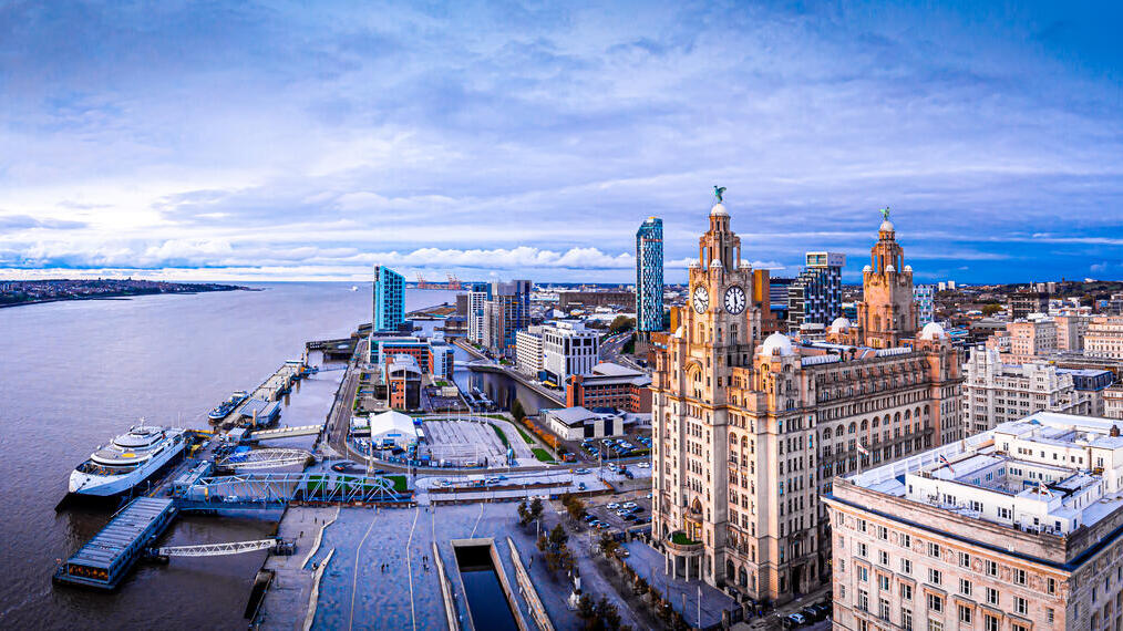 An aerial view of large city buildings overlooking a wide river.