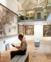 A man reading a book in the Stanley Spencer Gallery in Windsor