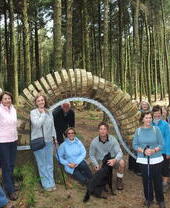 Eine Gruppe von Menschen, die neben einer Skulptur auf dem Pendle Sculpture Trail posiert