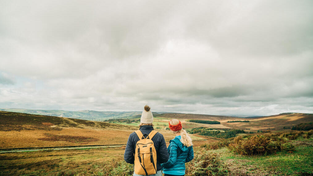 Two girls walking with panoramic views of greenery
