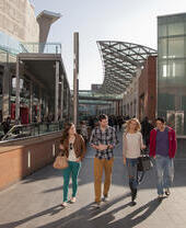 A man and woman, a young couple walking up the ramp outside the new shopping centre development and regeneration in the city.
