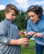 A woman and a child preparing a plant during growing activities at Northern Roots, Manchester