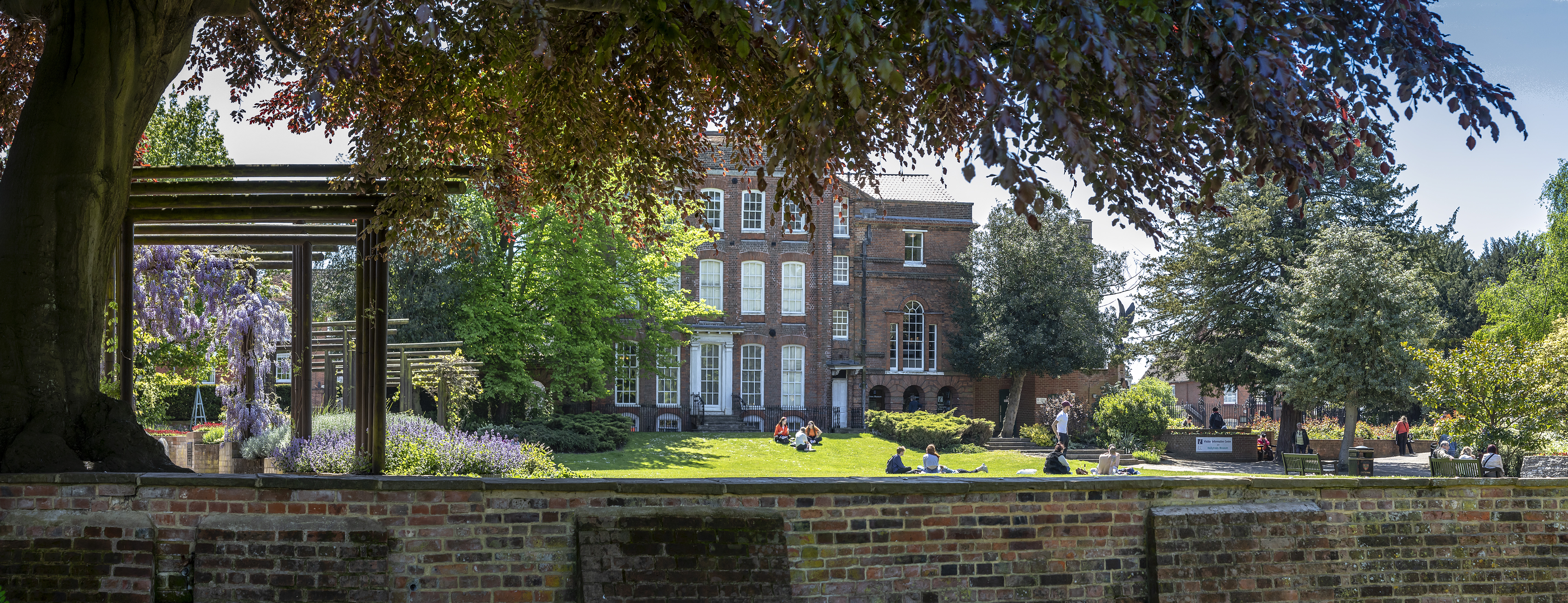 People relaxing in the grounds of Hollytrees Museum, Colchester