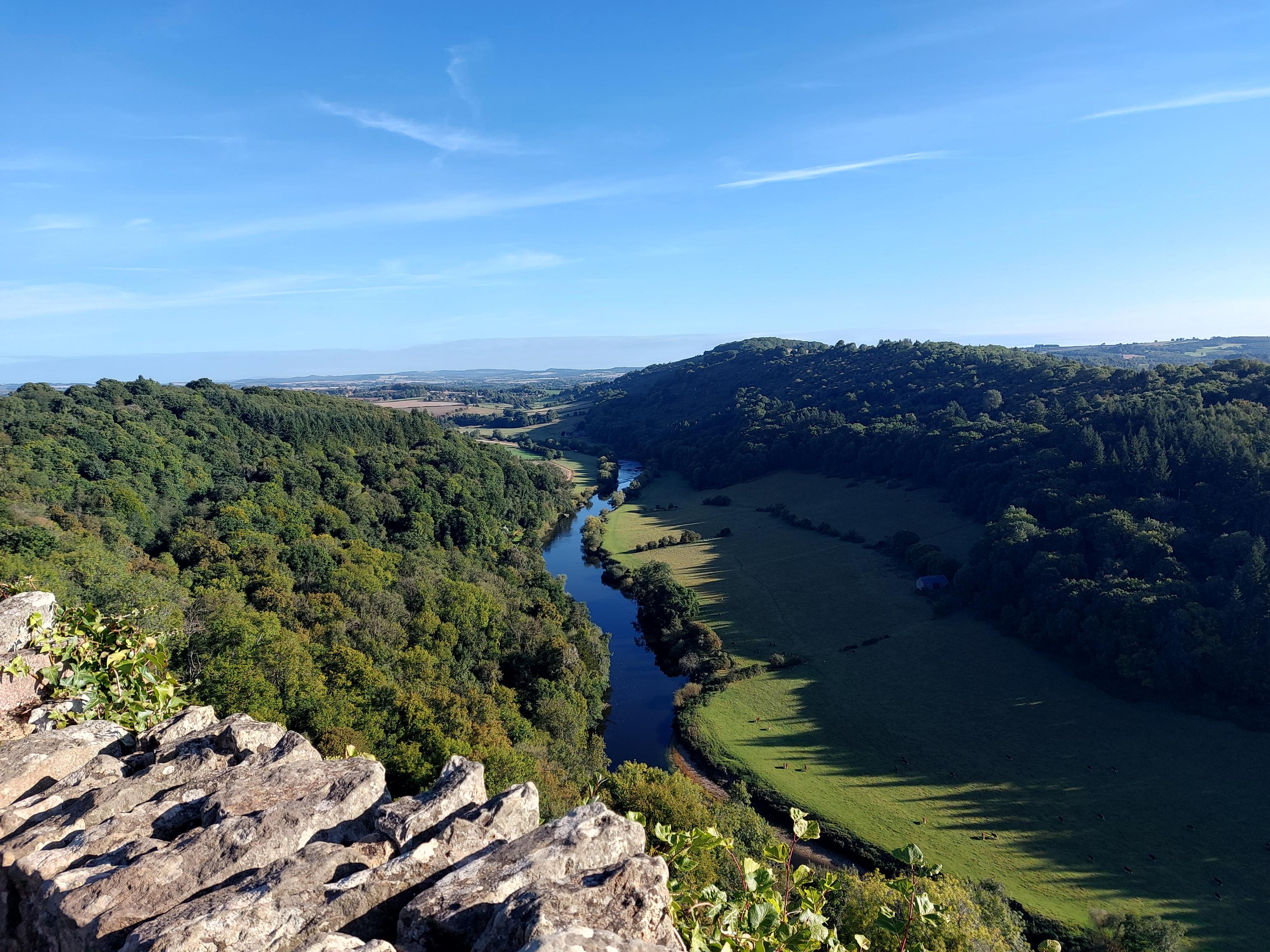 A rocky outlook surrounded by trees with a river below.
