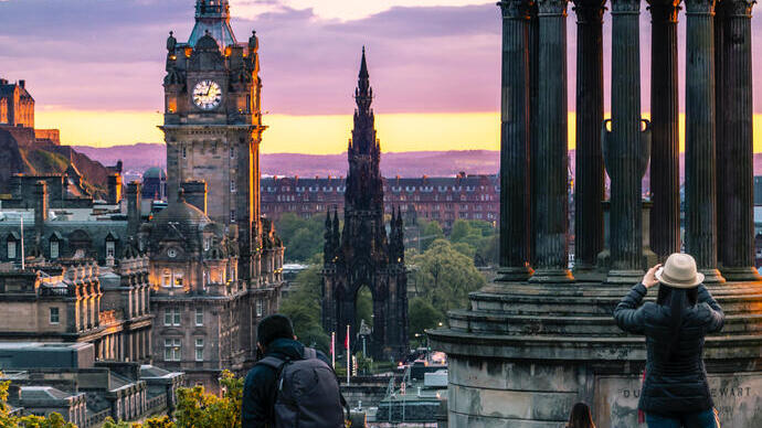 People looking at a city skyline and taking photographs of the view