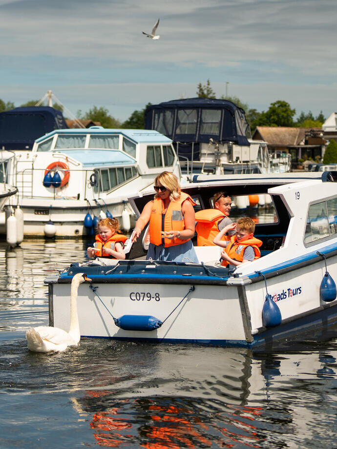 A family riding on a boat in the Norfolk Broads