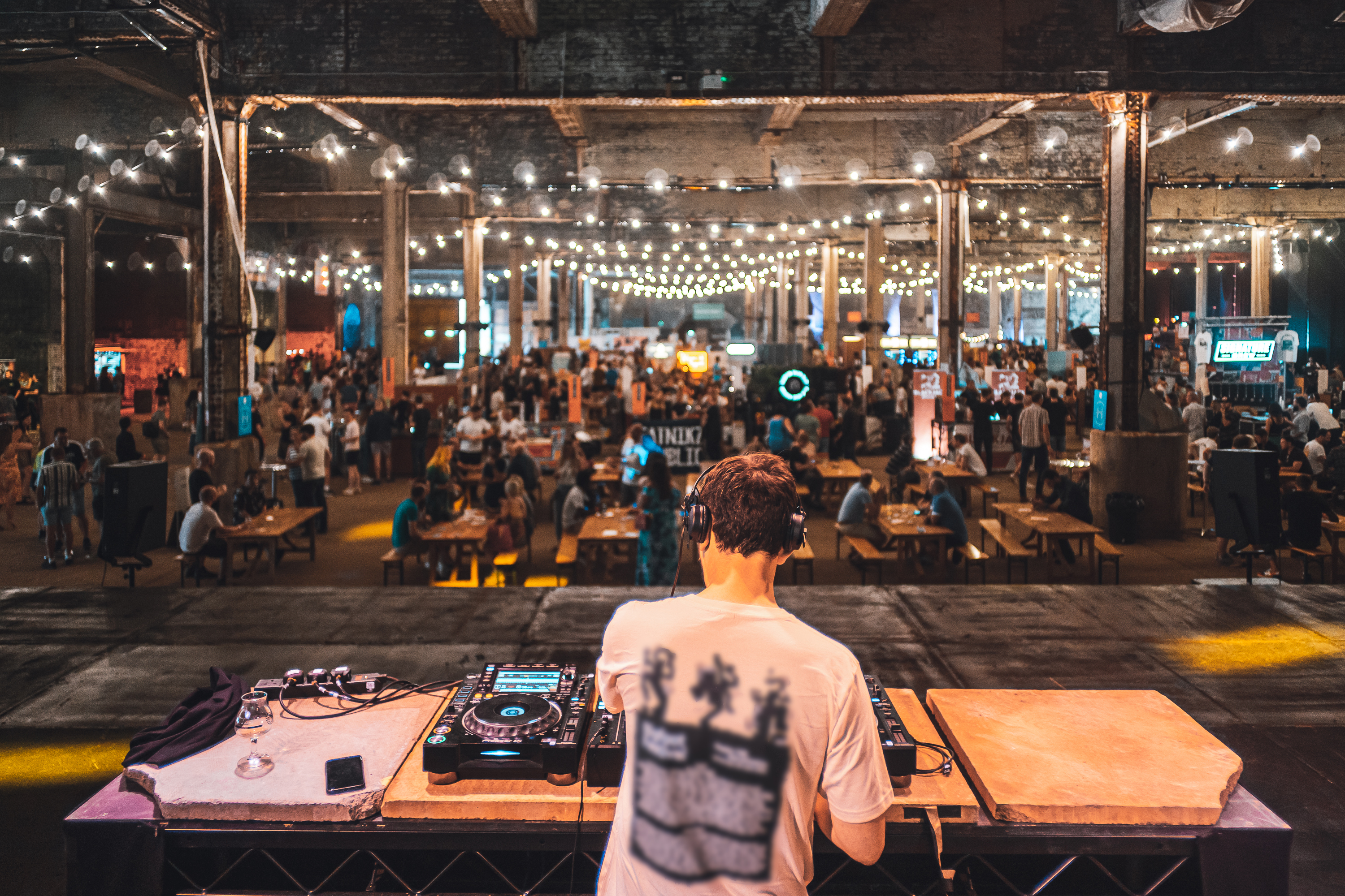 DJ playing to groups of people at Manchester Craft Beer Festival, in Depot Mayfield, Manchester