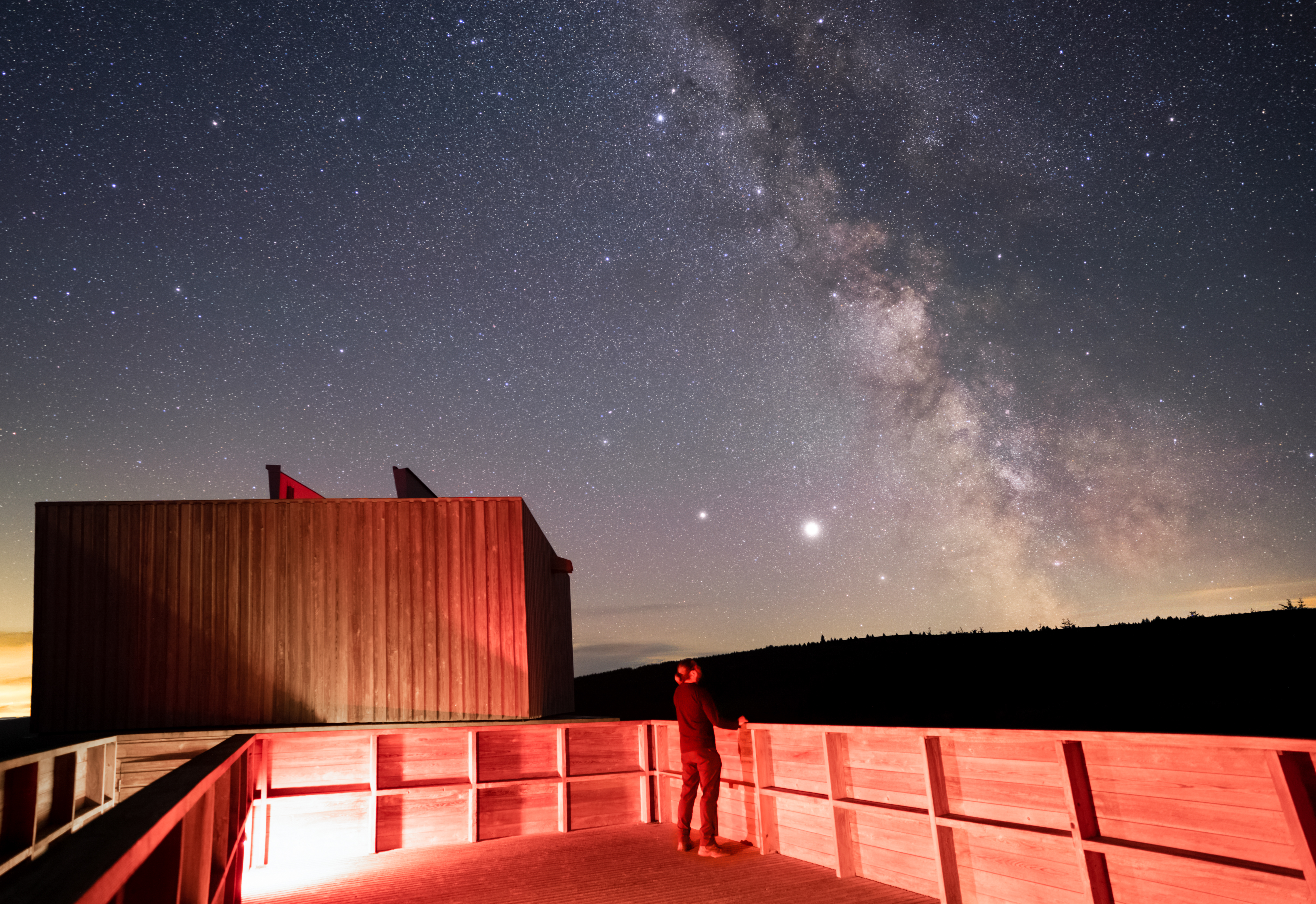 A person at the Kielder Observatory at night observing stars.