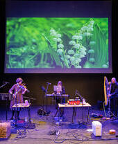 A band performing on stage with a variety of music instruments as part of Bangor Music Festival