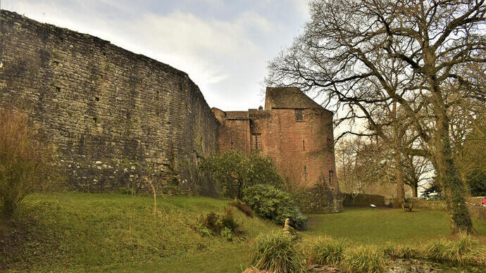 Extérieur d'un château en briques rouges et d'un mur fortifié en hiver.