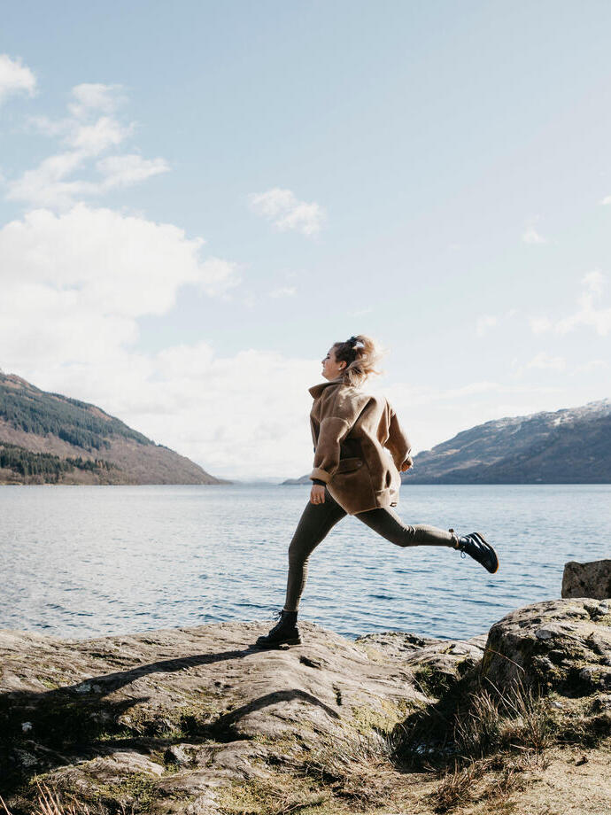 UK, Scotland, young woman running at Loch Lomond