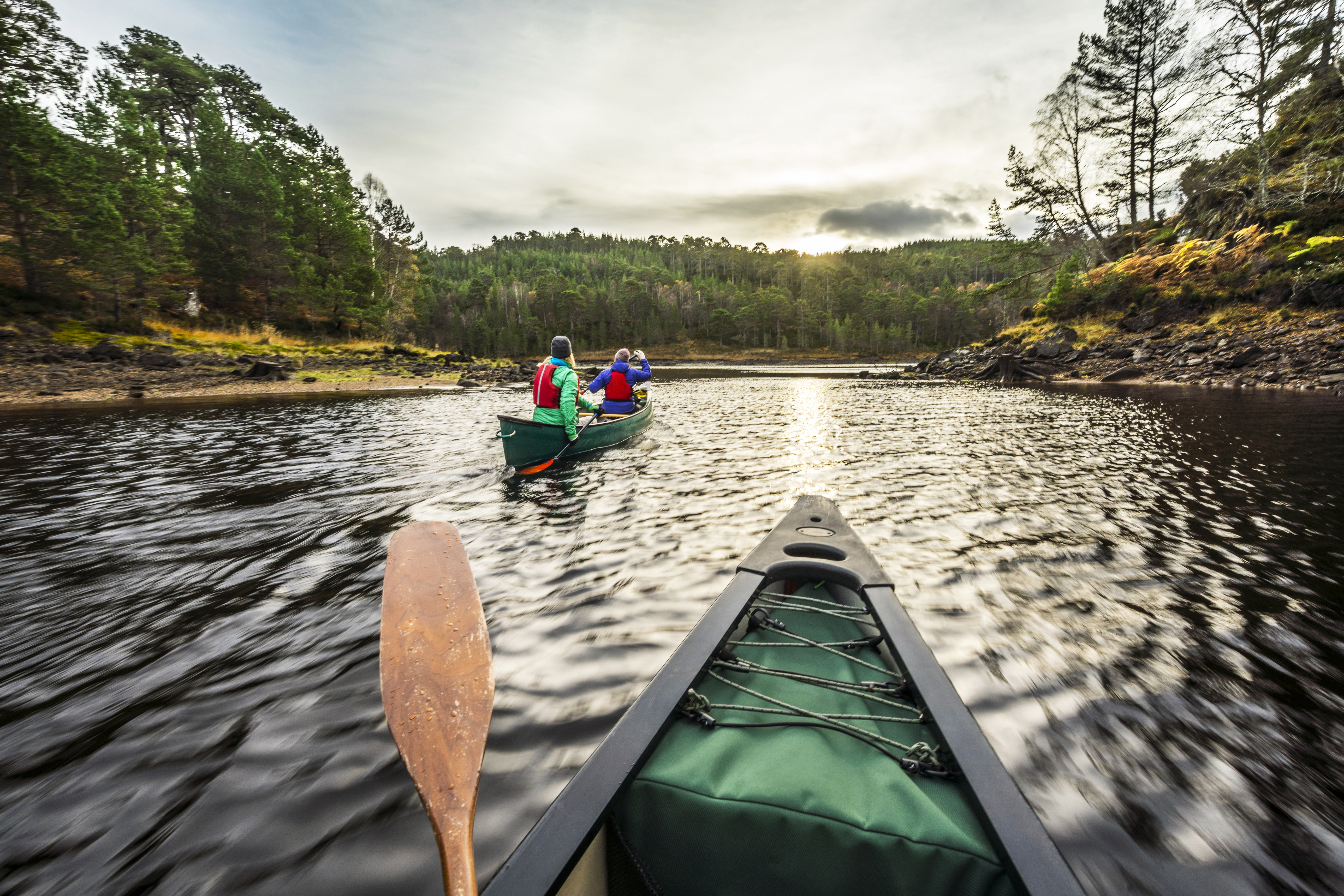Two women paddling canoes on water