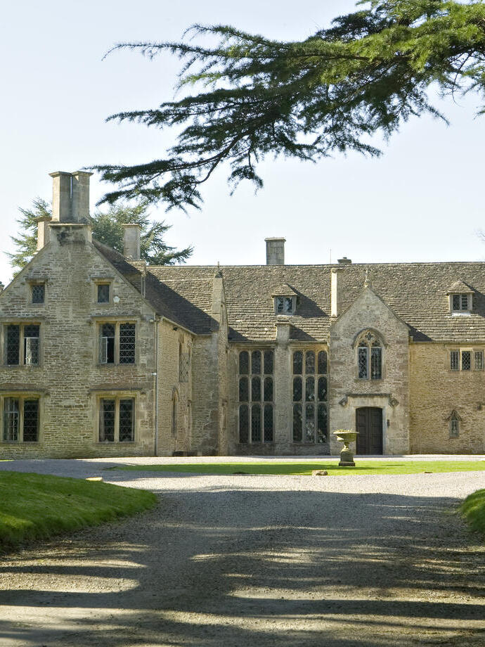 A stately Elizabethan Manor House and its manicured gardens.
