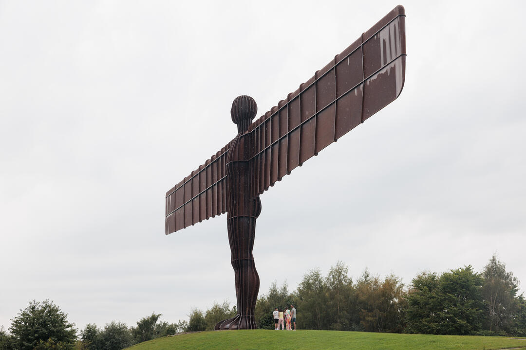 A family group visits the Angel of the North statue near Newcastle upon Tyne.