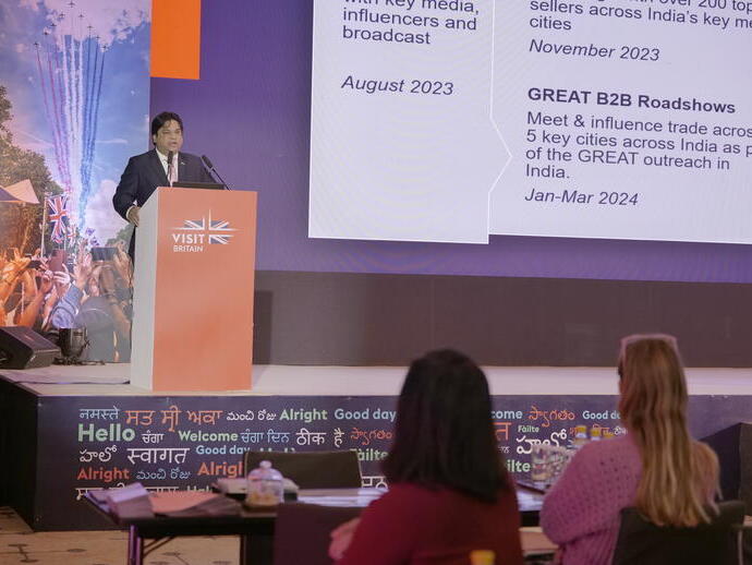 Un homme prononce un discours devant les délégués depuis le podium lors d'un événement