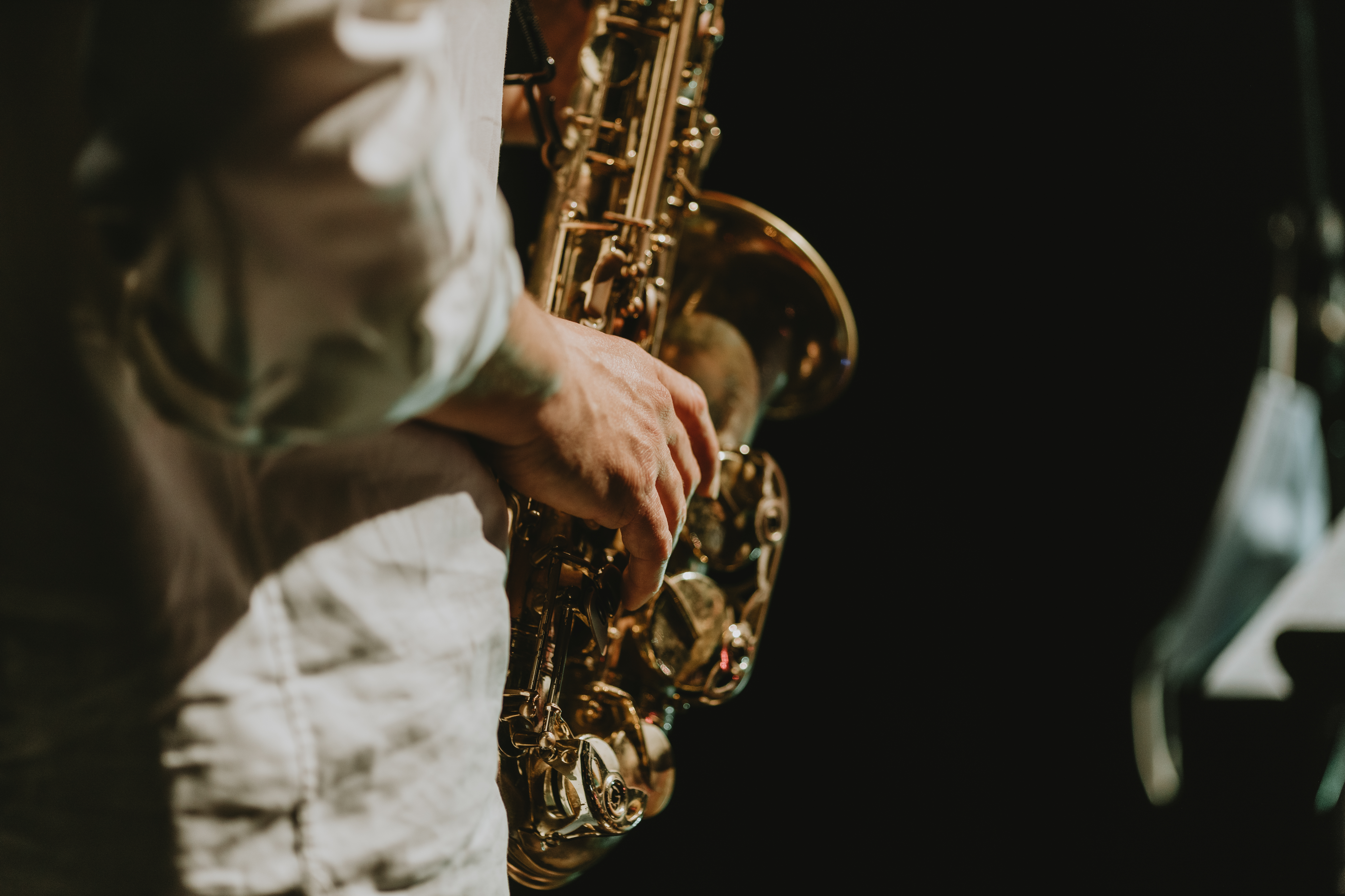 Un hombre tocando el saxofón en un escenario.